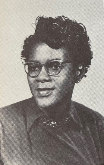 A young African American woman wearing glasses in a yearbook photograph