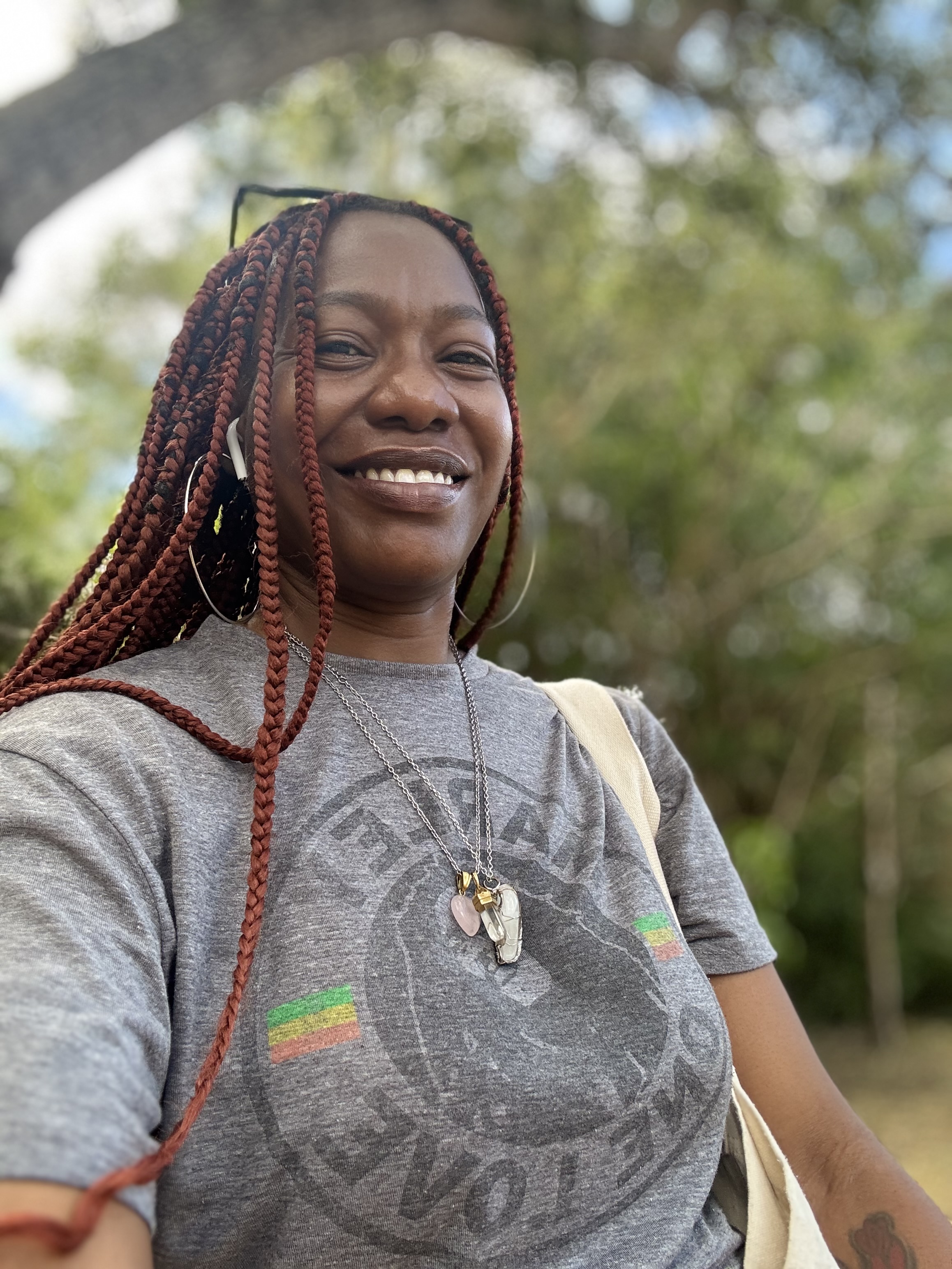 The writer, Robyn Ransome, is shown outside, smiling, her hair in long braids, with trees in the background.
