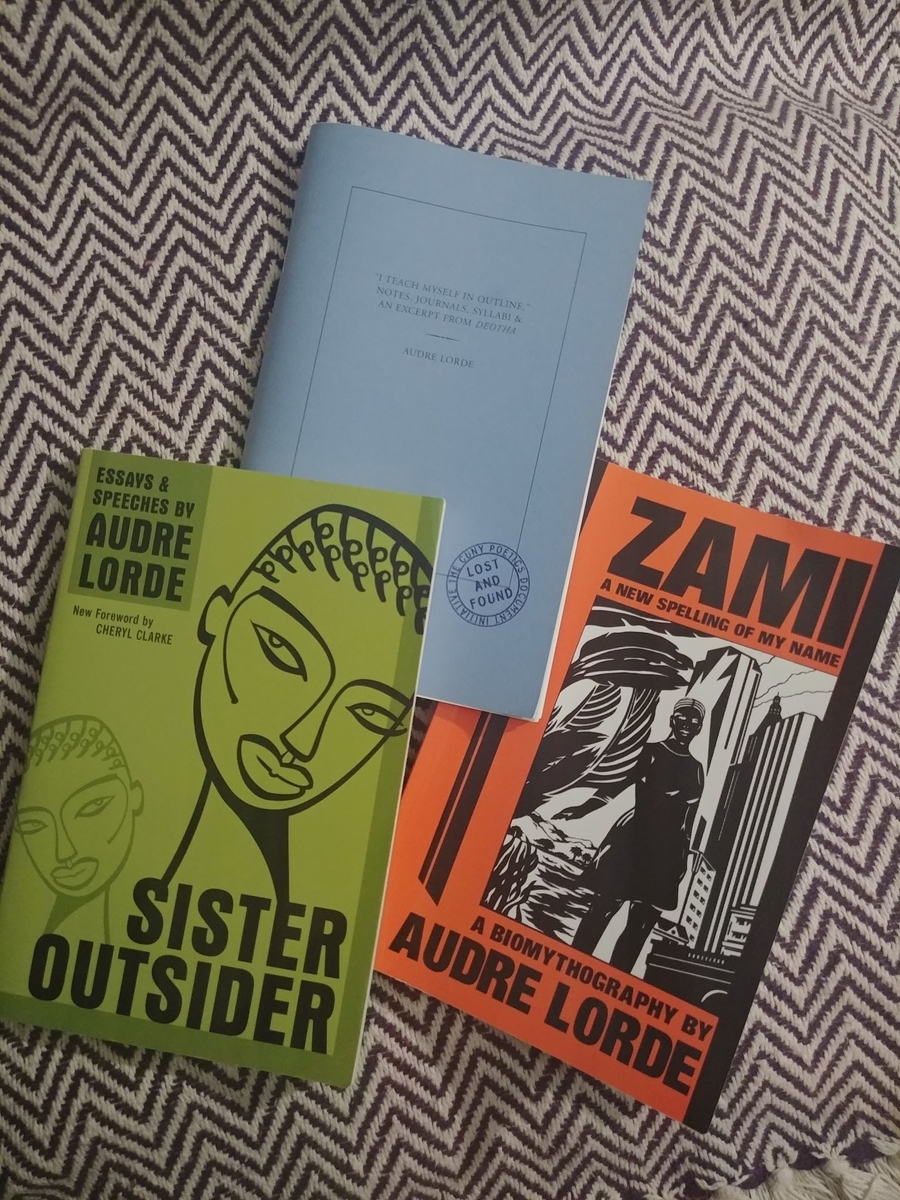 Photo of my copies of Audre Lorde's work, as mentioned in this essay (from top, counter-clockwise): "I teach myself in outline"; Sister Outsider; Zami.
