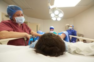 A nurse with a patient in the operating room.