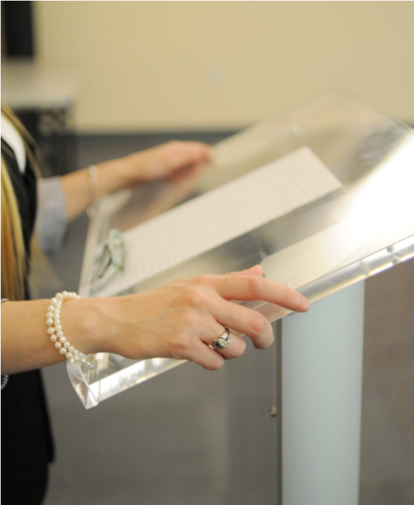 Student with hands on side of podium