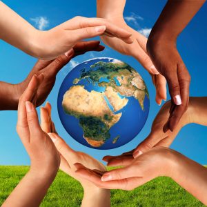 An image depicting several hands arranged around a globe as if the world was being cradled.