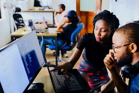 Photograph: two people looking at a computer together in concentration.
