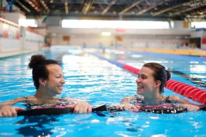 A recreational therapist with a client in a swimming pool.