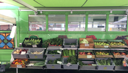 Close up shot of multi-tiered produce shelves lining the side of the converted bus.
