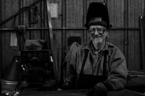 person smiling while wearing industrial welding gear