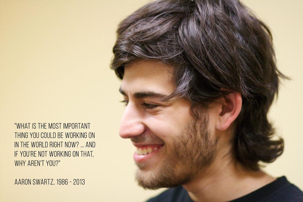Photographed side-profile portrait of social activist, Aaron Swartz, smiling. Next to his face is a quote reading "What is the most important thing you could be working on in the world right now? And if you're not working on that, why aren't you?".