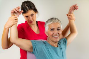 An occupational therapist with an older female patient.