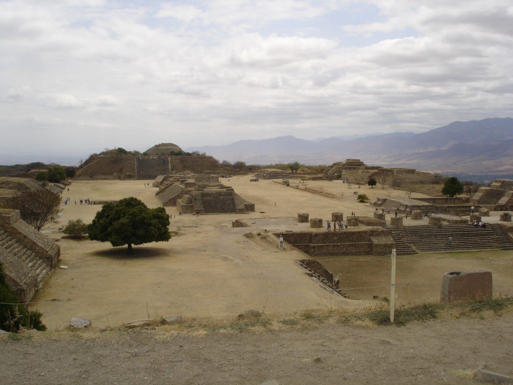Fig. 1 – Large open plaza of archaeological site of Monte Albán, pyramid mounds close by and mountains visible in the distance. 