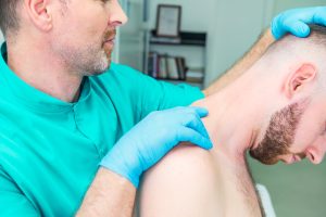 A chiropractor examines a patient.