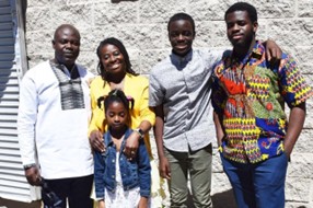 The writer, Eric Agyenim-Boateng, is shown outside with his four children and they are all smiling.