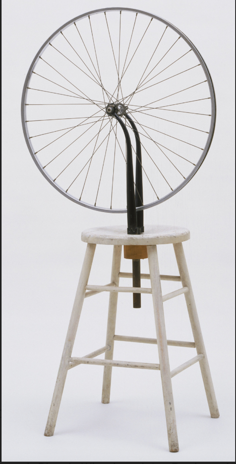 A bicycle wheel on a stool

Description automatically generated
