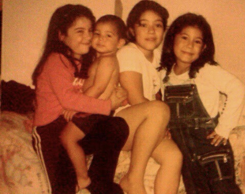 The writer, Estefania Valencia, is shown as a child wearing overalls, seated with her two sisters and toddler brother.