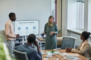 two people by a display giving a presentation