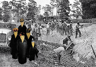 Administrators with identical, elongated faces watch convict labors from a Florida prison work at hard labor.