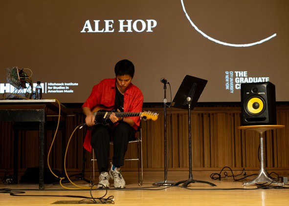 A person playing guitar on stage
AI-generated content may be incorrect.