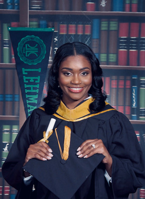 The writer, Shanique Bowden, is shown smiling wearing her graduation gown and mortarboard (graduation hat) from Lehman College.