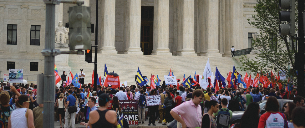 An image of a group of people at the steps of the Supreme Court building. Many people are holding flags marked with the symbol of an equals sign.