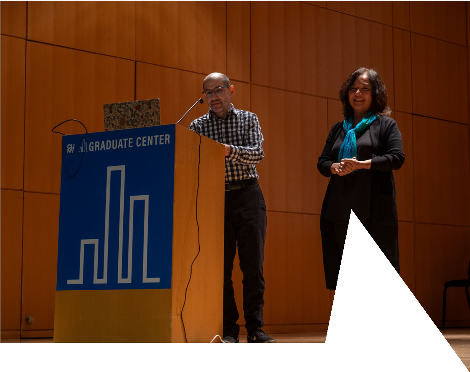 A person standing at a podium with a person standing behind him

AI-generated content may be incorrect.
