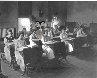 From the back of the room, a two headed creature with gray skin watches students in an 1890 University of Alabama classroom.