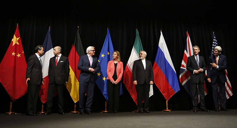 Color photo of representatives of China, France, Germany, the EU, Iran, the UK, and the United States posed for a photo in front of flags