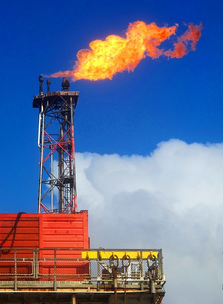 A flame shoots out of a metal tower on an oil rig.