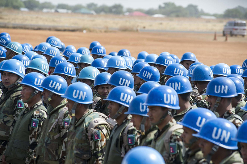 Color photo of UN Peacekeepers wearing blue UN helmets
