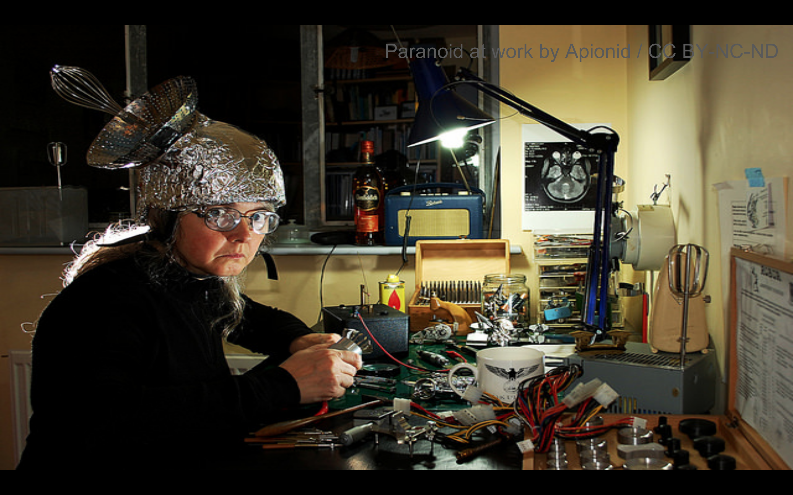 Person wearing a tin foil hat while wiring equipment