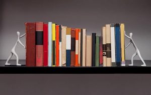 lined up books being held up by stick figures