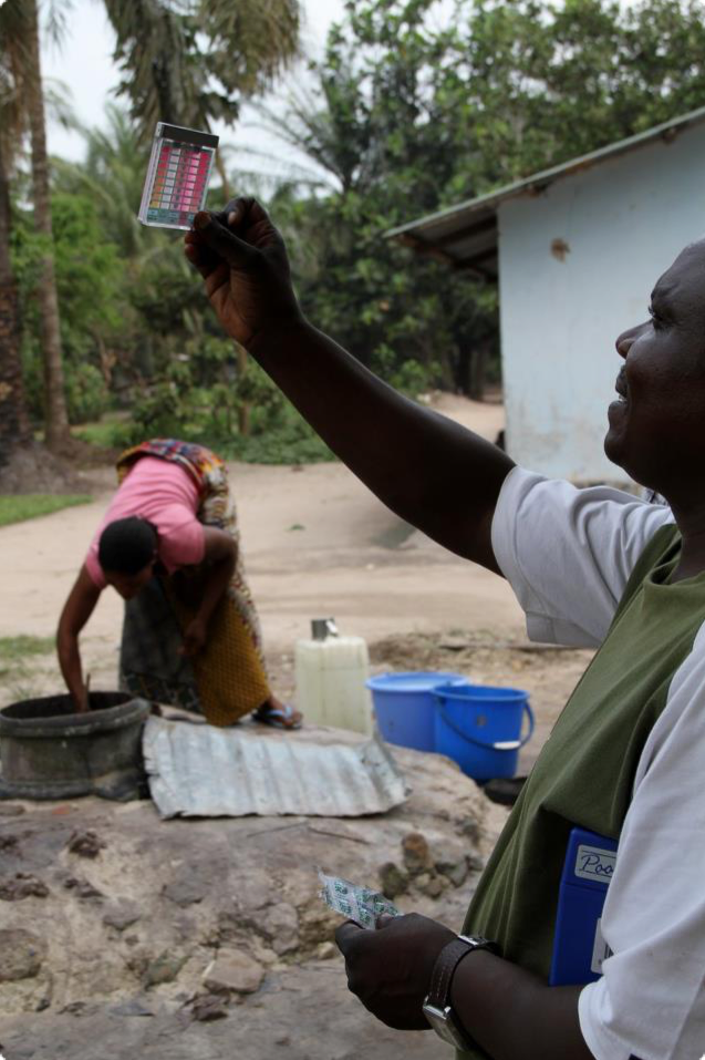 Person checking water quality using a chemical test.