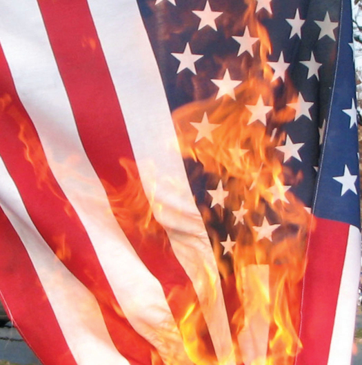 A photo of an American flag. The flag is on fire.