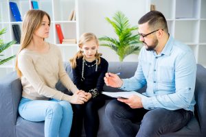 Male social worker meeting with mom and daughter.