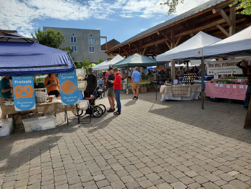 Couple and their child waiting in line for baked pretzels and pizza.