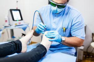 A podiatrist performing a procedure on a patient's foot.