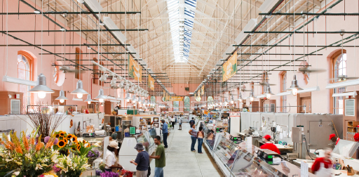 Interior of Eastern Market after renovation 2009. Several patrons are stopped at very stalls looking at the products. A lot of natural light coming thorugh the windows and skylights.
