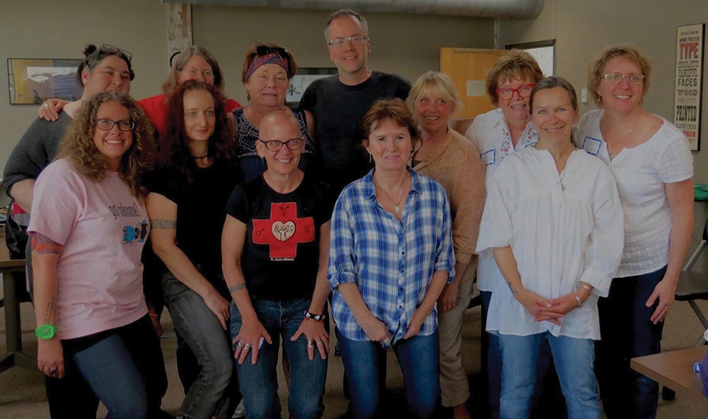 Group photo of ten Harm Reduction History Harvest participants posing in the venue with Professor Amy Sullivan and community coordinator Sue Purchase.