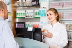 A pharmacy technician helps a patient.