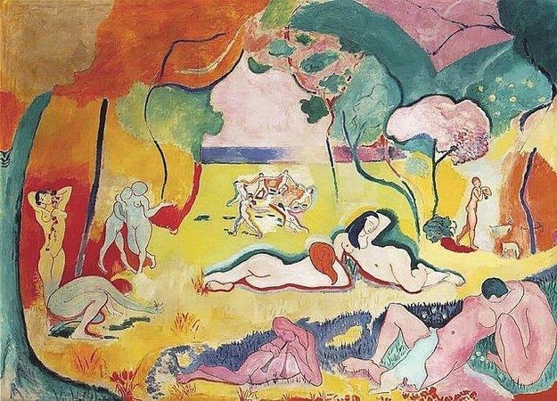 Numerous naked men and women lie lazily about a green field with trees. 