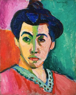 A Matisse Fauvist painting of a woman from the shoulders up starring ahead. The background is green, pink and red and you can see the brushstrokes. She wears a red top with a green v neck collar. Her black hair is tied up in a bun. 
