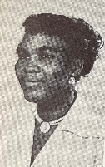 A young African American woman wearing earrings and a necklace in a yearbook photograph