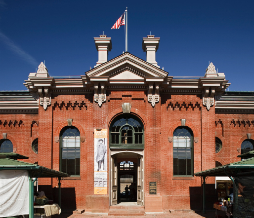 Eastern Market entrance showing brick detailing and large windows. An American flag sits atop the building.