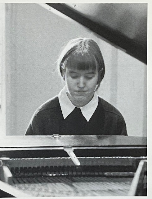 black and white photo of a teenage girl at piano