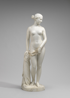 Hiram Powers' 'Greek Slave' is seen against a neutral background. The marble statue depicts a nude woman who has chains hanging from her wrists.