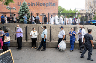 Lincoln Hospital workers lined up to get care packages containing snacks and sanitizers donated to Hospital workers by The Robin Hood Foundation and billionaire Leon Black. The project is called "NYC Healthcare Heroes." East 149th St. at Morris Ave., Bronx. Photographer: Camilo Vergara